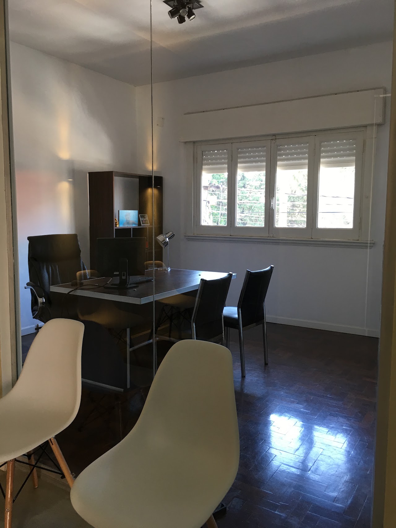 Modern executive conference room and private attorney office desk with legal books, architectural wooden shelves, laptop, clean desk accessories, warm gold and deep navy ambient lighting, elegant professional law firm interior, high quality photography.